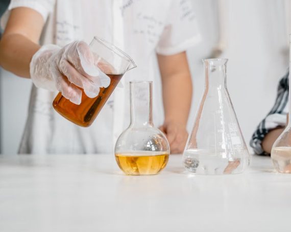 Children in a science lab conducting an experiment with beakers and liquids.